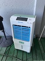 Full view of Duo Lang outdoor air cooler showing white and blue body with caster wheels and water reservoir.
