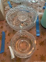 Photo showing the large and small cut glass bowls with intricate cut patterns, and a glass heart inside the large bowl.
