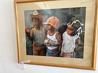 Framed painting featuring three children, capturing detailed facial expressions and clothing.