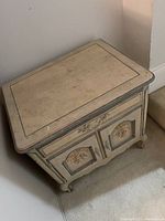 Top angled view of the wooden nightstand showing floral painted two-door cabinet and drawer with distressed paint finish.