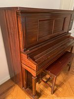 Side view of the upright Haines Bros. player piano showing wood finish and structural design.