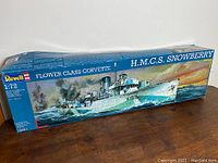 Photo of the unopened Revell Flower Class Corvette model kit box featuring artwork of HMCS Snowberry in a naval battle scene on the ocean.