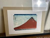 Full view of framed woodblock print on white mat board