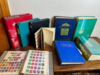 Wide view of all seven stamp albums arranged on table.