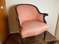 Front view of armchair showing curved back, rolled arms, and seat