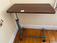 Wood grain laminate rectangular tabletop with rounded edges, showing minor surface wear.