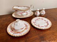 Full set of 4 items on wooden surface showing all included pieces with floral and gold detailing.