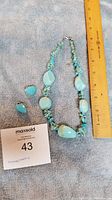 Full view of turquoise necklace with ruler for size reference showing approximately 16 inches