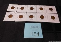 Photo showing 10 USA pennies from 1950s-60s, each secured in individual protective holders with handwritten labels.