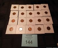 Image showing 21 American pennies dated from 1950 to 1982 laid out in rows, each in individual protective holders.