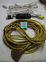 Top view showing the three cords: one yellow 50-foot 3-prong extension cord with a heavy plug and two white 15-foot 2-prong cords, along with black portable ground fault interrupter box