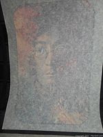 Individual close-up photo of John Lennon T-shirt transfer on tissue paper.