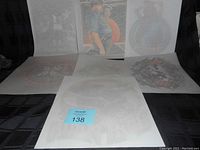 Overview of all six vintage 1970's T-shirt transfers arranged side by side on black fabric