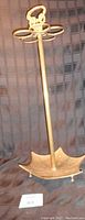 Full view of the brass umbrella stand showing the entire piece including the umbrella-shaped base and the top handle.