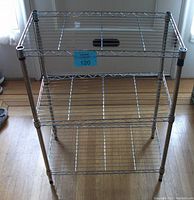 Front view of the chrome 3-shelf kitchen rack showing wire grid shelves and supporting vertical poles.