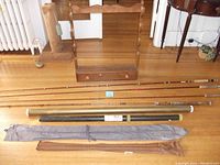 Full view of rods laid on floor with cases and wooden rod holder in background