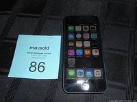 Front view of Apple iPod Touch showing home screen with app icons and home button.