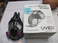 Uvex Bionic Shield box with the respirator mask placed beside it on a white surface.