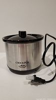 Mini Crockpot Little Dipper showing stainless steel body with black lid and power cord.