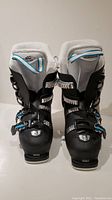 Front view of both Salomon XPRO S women's ski boots, black and white with blue and silver buckles