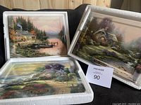 Three Thomas Kinkade plates in white protective foam and boxes, showing overall lot condition and packaging.