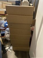 Eight sealed cardboard boxes stacked vertically containing glass jars.