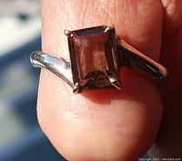 Close-up of the amethyst ring showing the stone's translucent characteristics on finger in natural light.