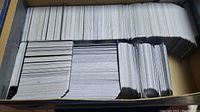 Large box filled with many sleeved Magic: The Gathering cards.