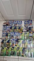 Full lot of 32 Star Wars action figures in packaging arranged on floor
