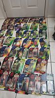 Wide angle showing the entire lot of 40 packaged Star Wars action figures arranged on the floor.