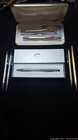 Overview of six pens and pencils including gold-filled and silver-tone items, with original branded cases