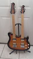 Front view of double neck guitar on stand showing overall shape and finish