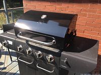 Front and side view of black Master Chef BBQ grill with lid closed, showing control knobs and side burner.