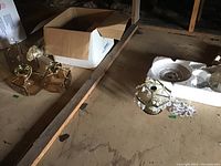 Photo of two matching boxy light fixtures with brass bases and clear glass covers along with the vintage hanging fixture in open cardboard box on floor