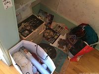 Photo showing vintage wicker sewing box, white yarn, scissors, and various papers and patterns spread around, bundles of yarn in bag.