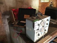 Photo of vintage Precision Signal Generator and Tube Tester devices, showing overall condition and setup in a storage environment.
