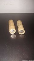 Two paper rolls containing 1967 Canadian silver nickels, showing ends and partial side labels, placed on a dark surface.