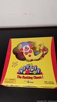 Closed game box packaging showing cartoon clown figure shaped window and game branding