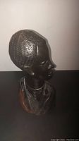 Side view showing textured hair and profile of the bust along with minor wood cracks