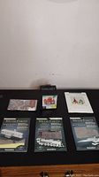 Lot laid out on black surface - shows four Metal Earth model kits in boxes, two small flat paper cutting kits, and one boxed Finger Art wooden model kit.