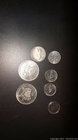 Various Canadian coins including a silver quarter with a cougar, silver nickels with rabbits, commemorative dollar coins, and a 1945 nickel, all with minor surface wear.