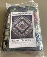 Kyoto Gardens quilting kit pattern and fabrics sealed in original plastic wrapping, shows finished quilt image and kit branding.