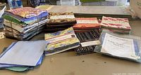 Photo of assorted quilting fabric squares arranged in bundles and stacks on a table showing various colors and patterns