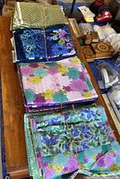 Bundles of quilting 100% woven cotton fabric in various colors and patterns, stacked and tied with string