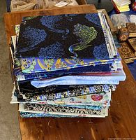 Top view of a fabric bundle featuring a layered stack of varied patterns in mostly blues with peacock and floral themes.