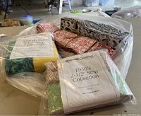 Bags of fabric strips on table showing labels 'Crayon Box 2 1/2" Strip Collection' and 'Keepsake Quilting 1930's 2-1/2" Strip Collection'