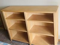 Photo of a solid maple bookshelf showing its full front view with six shelves divided by a center partition.