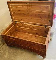 Open view of vintage solid wood hope chest showing interior and open lid.