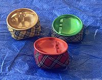 Three vintage MSM beanbag ashtrays in red, yellow, and green plaid fabric with matching colored metal tops, displaying front and top views.