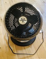 Front view of black Vornado 660 air circulator fan with spiral grill and central Vornado logo.